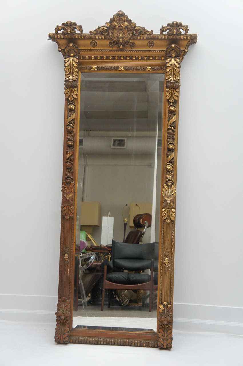 a wonderful gilded gold mirror that works in any interior.
Nice long size. Great for the end of a hallway, leaning against the wall in a bedroom, above the fireplace. Suit yourself. In great condition with slight clouding in a few spots. Does not