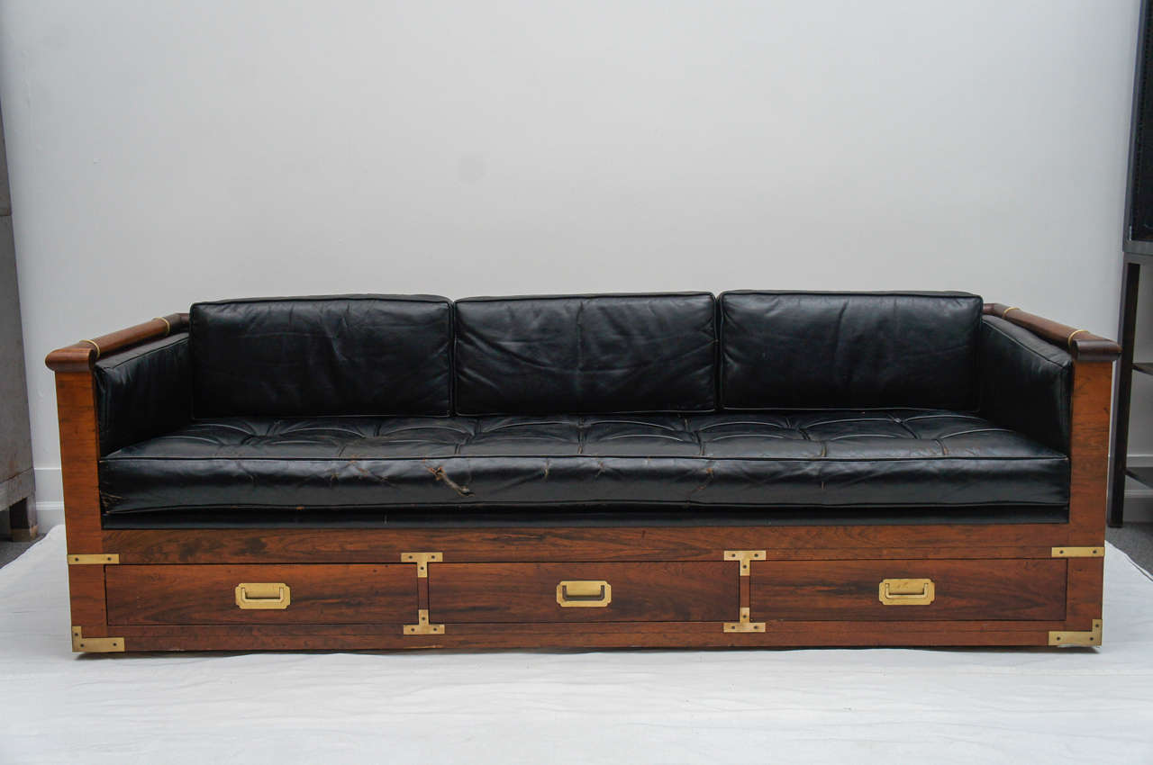 great piece period. A Marge Carson design.
Great style, great size, great rosewood grain, great brass detail, great hidden drawers. Not so great upholstery. There is a tear to the front of cushion which could easily be swapped out. Otherwise the
