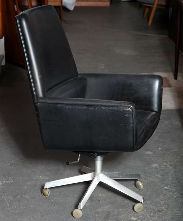 Executive Desk Chair by Finn Juhl.  Features original black leather upholstery and aluminum star base on casters.