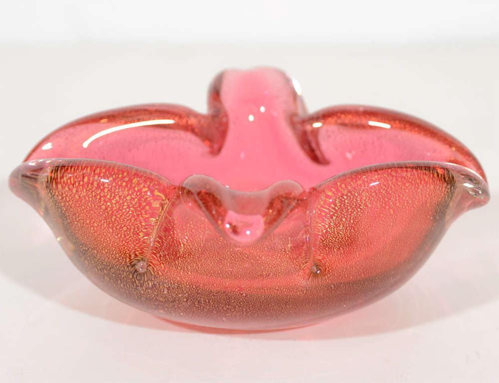 Modernist ashtray or bowl in the form of a stylized lily.  Hand blown Murano glass
in hues of Venetian red with 24K gold flecks details.