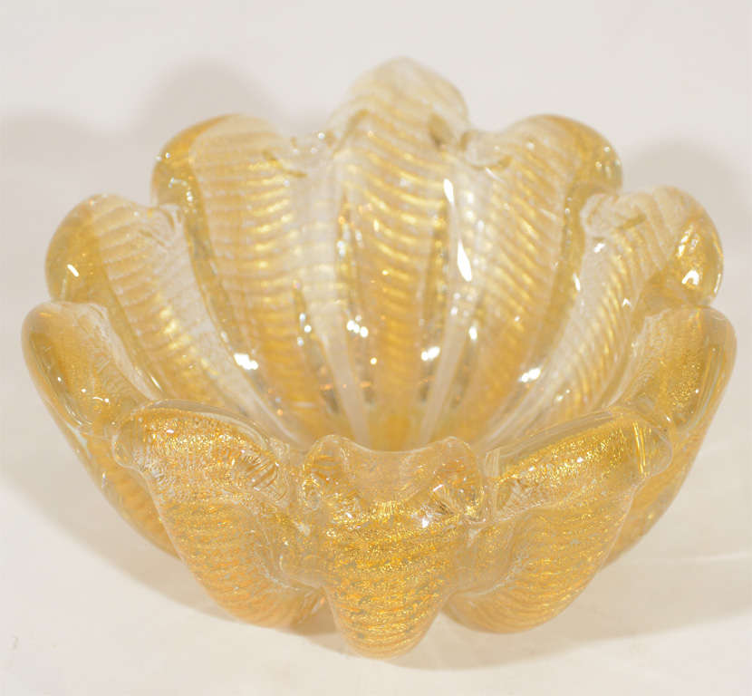 Beautiful hand blown Murano glass bowl or ashtray with stylized shell form
with fine 24K gold flecks throughout and fluted sides.