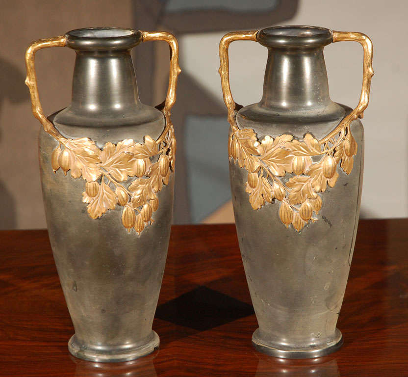 Pair of bronze, urn shaped vases with applied brass floral design by Kaiser.