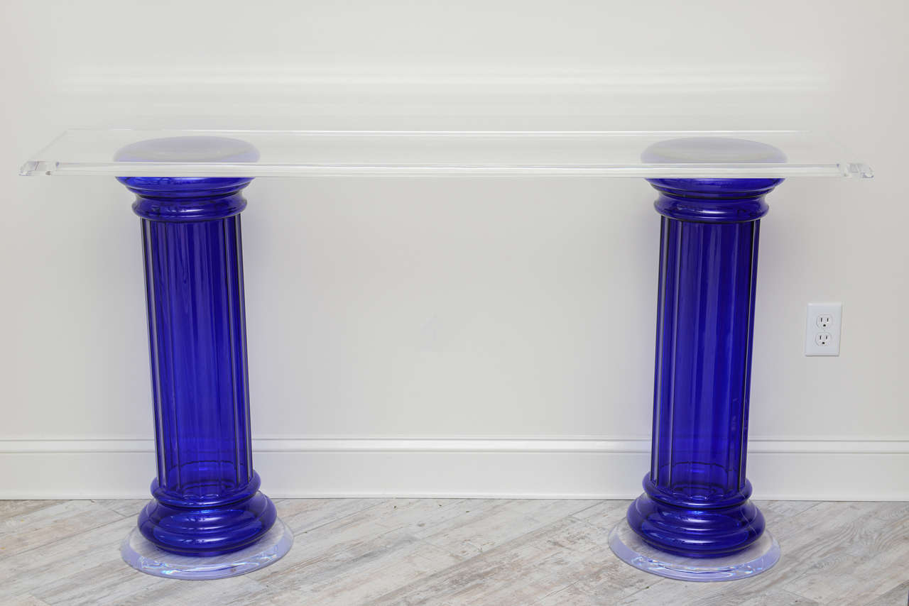 Striking cobalt blue glass fluted columns with Lucite bases and Lucite top with beveled edge.