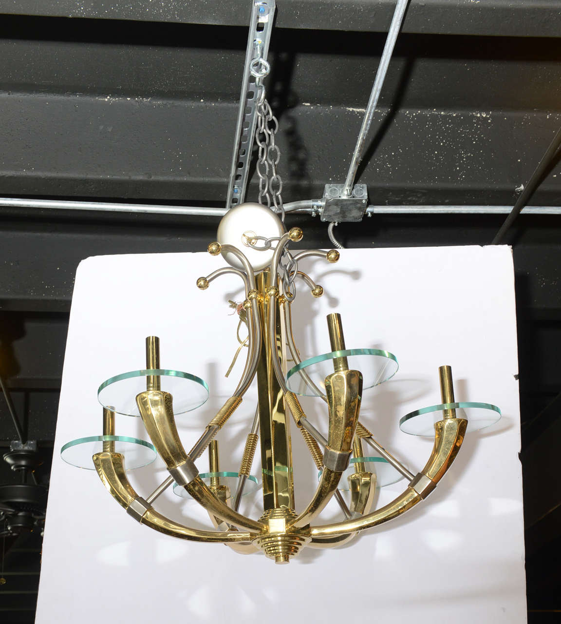 Striking modern brass and steel six-arm chandelier with glass bobeches.