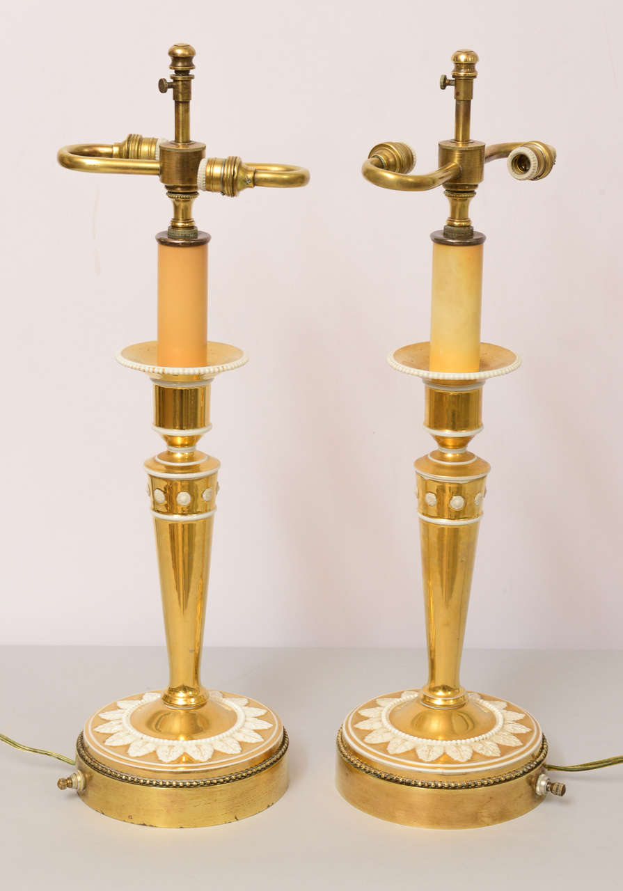 Pair of column-form candlesticks, of gold gilded porcelain with delicate white overlays, on round beaded brass base; lamped.

Stock ID: D9150