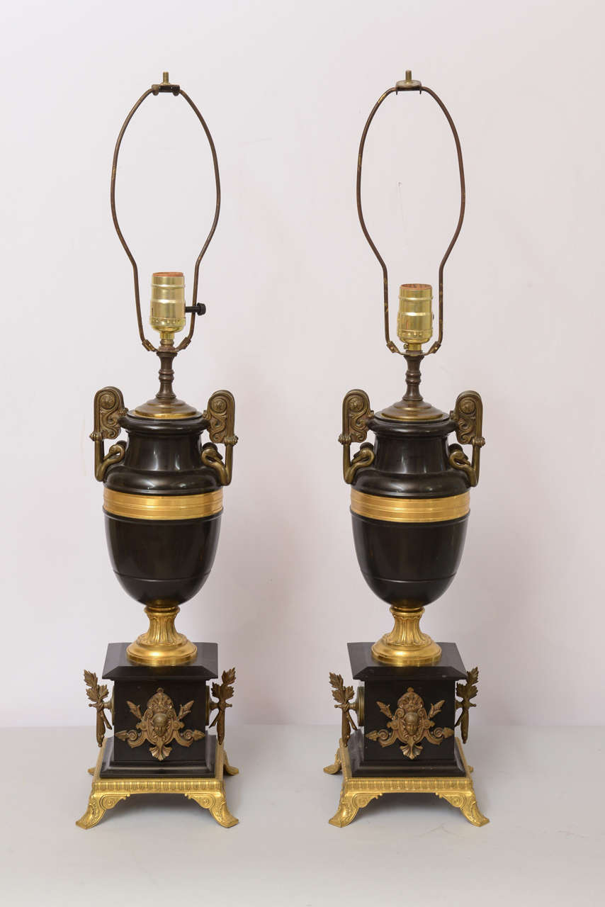 Pair of amphora urn-form lamps, of Belgian black marble, accented with dore bronze band, raised on round foot, set upon square plinth with ormolu.

Stock ID: D6771