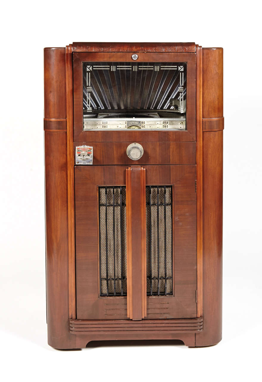 Striking deco design from Seeburg in 1936.
Fully restored and functional.
Original walnut and veneers, original etched glass plate, original nickel & enamel coin mechanism and selector switch.  Vintage grille cloth, possibly replaced at some