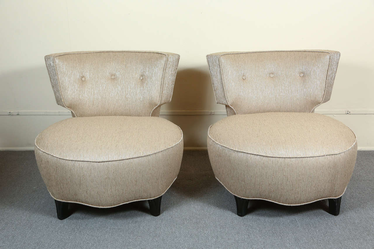 Glamorous pair of Hollywood regency slipper chairs.    The barrel form seats are up on small legs while the backs curve gracefully around.
They are newly upholstered in a glamorous ribbed metallic fabric.