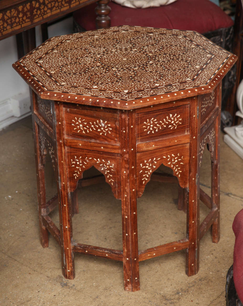 An octagonal end or side table with bone inlays in a classic pattern from India throughout. Foldable base.