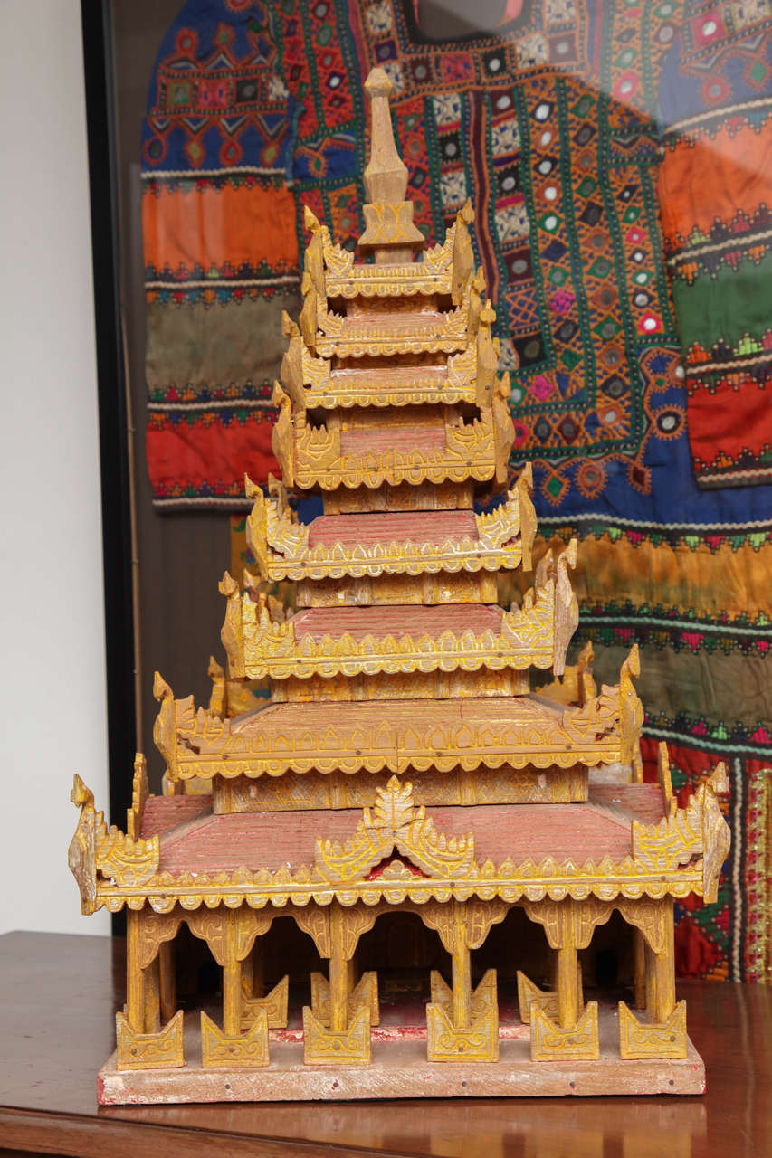 A hand-carved miniature Thai temple in wood, painted gold and red with finely carved details. A model for a temple of the Mon people in southern Burma. 80 years old.