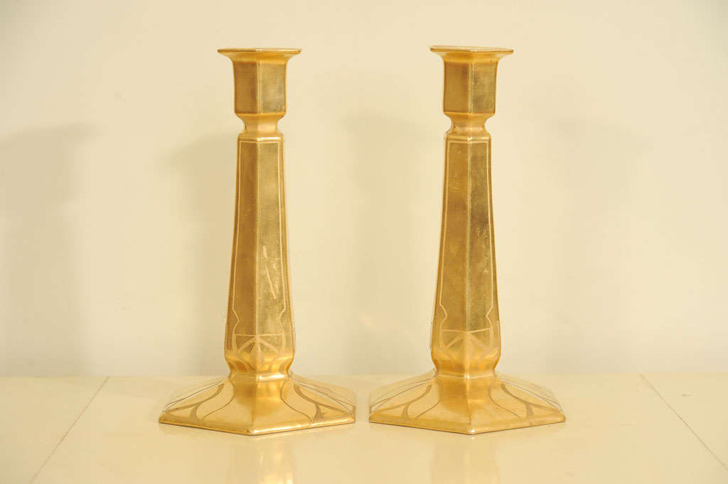 A pair of fine Porcelain candlesticks leafed in 18ct gold and incides with an art nouveau pattern with a Limoges stamp ot the bottom.