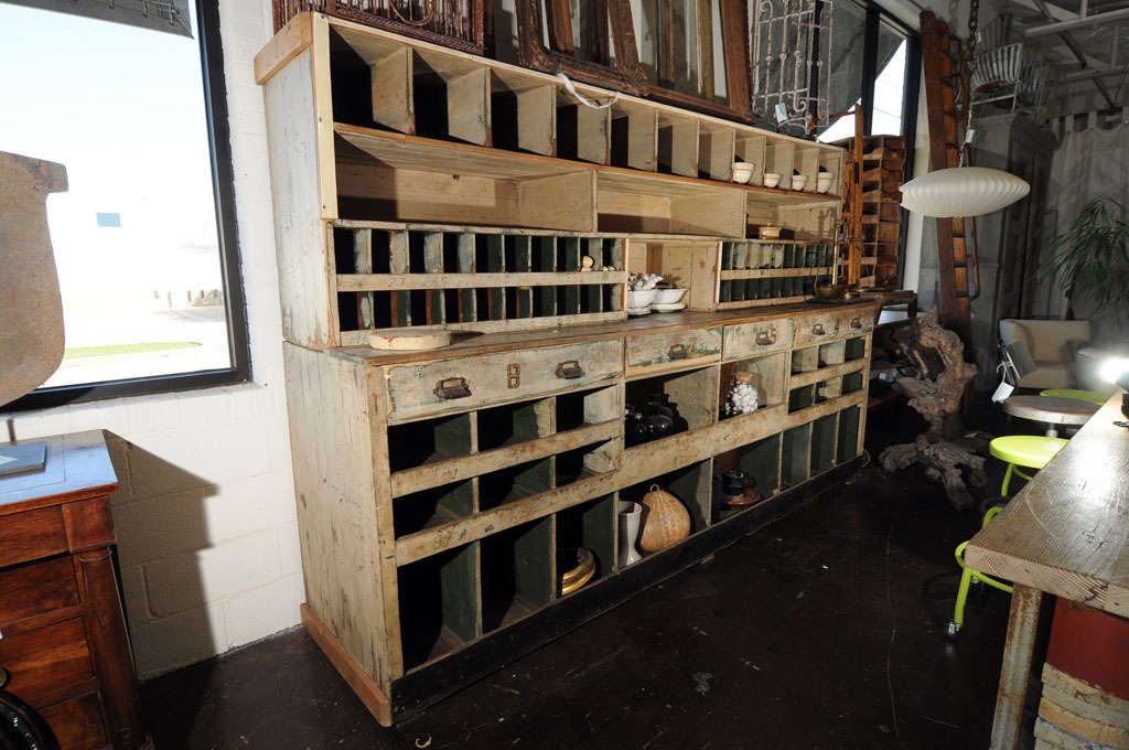 Two Piece Mercantile Cabinet with 73 cubbie holes of various sizes and 4 pull drawers.