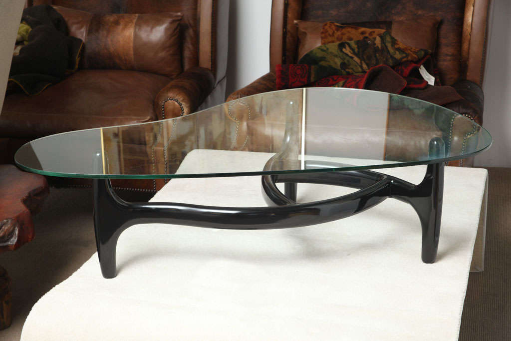 Kidney shaped glass top on a black lacquered bent wood base...very architectural