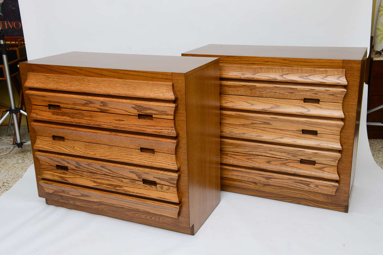 Beautiful uniquely sculpted drawer fronts highlight this pair of exceptional oak Romweber dressers, their design by Harold M. Schwartz. Beautifully figured rich warm oak with the drawers a hue lighter highlights these exceptionally solid and well