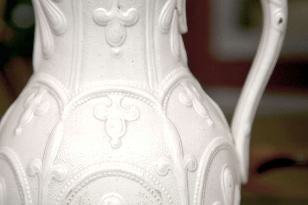 Gothic style patterned Parian Ware pitcher produced by Wedgewood. Pewter lip remains around the spout.