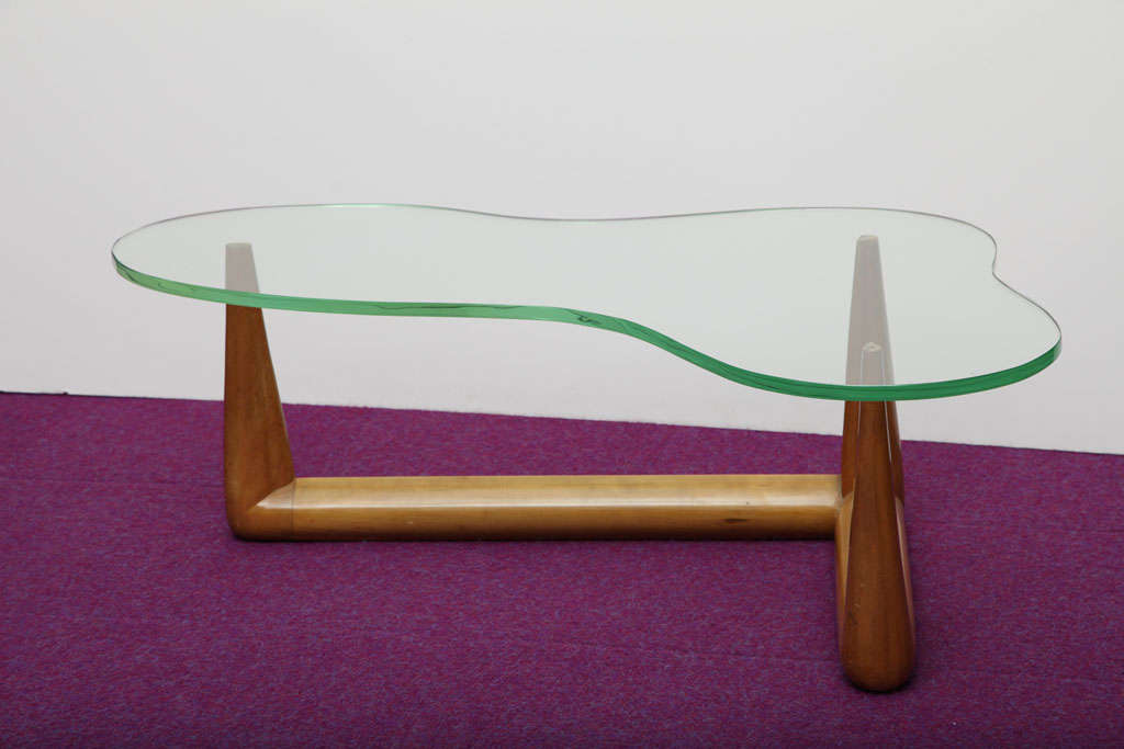 Bleached walnut base of cylindrical forms and reversed-tapered legs.  Thick glass top of irregular shape.  This piece was designed by Gibbings and produced by Widdicomb.