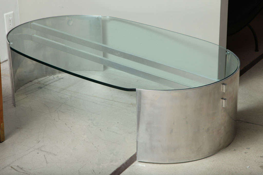 Massive polished aluminum arcs joined by two square staves support a thick glass top. Unknown designer, France, 1970s