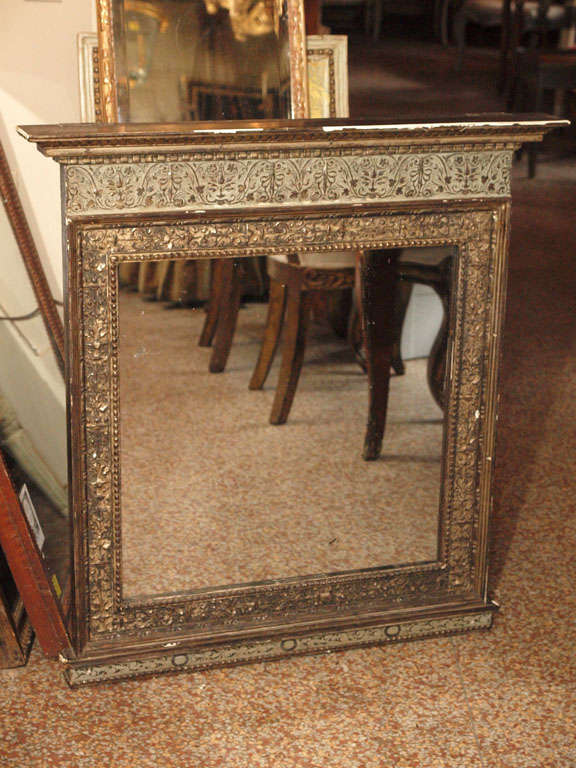 An Italian mirror, Renaissance style, carved wood, silver leaf and patinated.