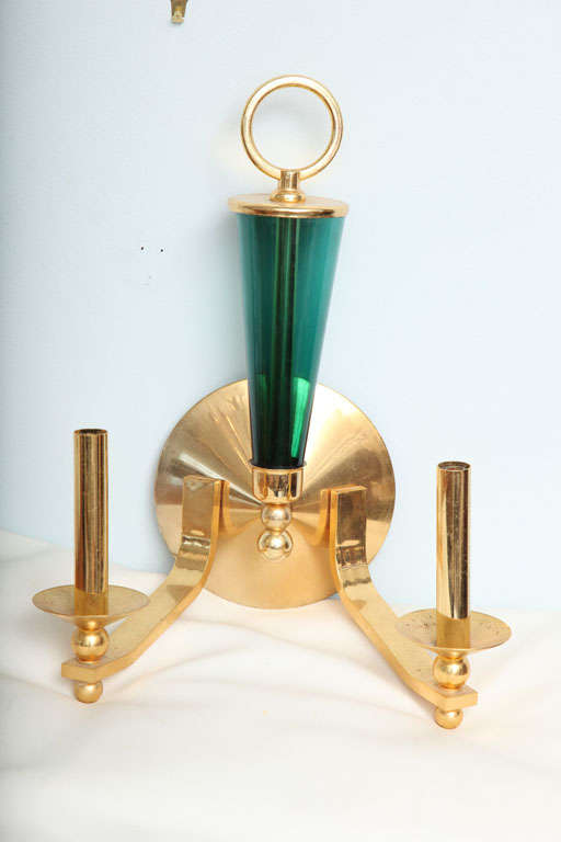 The metal ring with emerald green glass cone above a round backplate and two lights.
