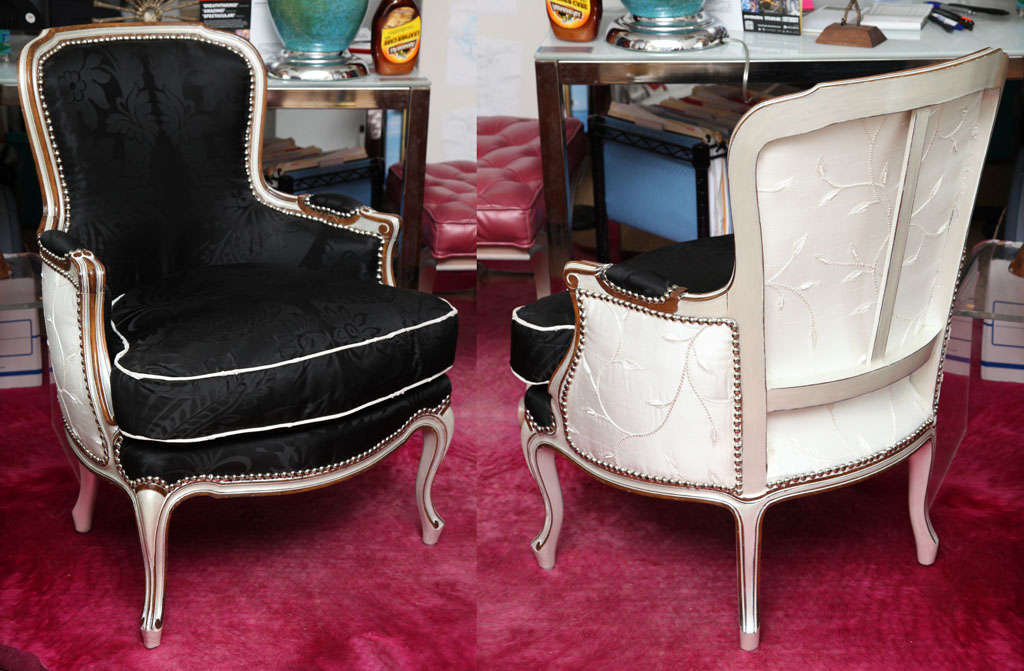Pair of Louis XV style bergeres upholstered in silk with pearl finish and nickle nailheads.