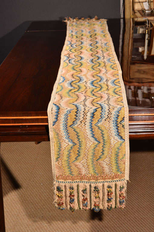 a long 18th century George III woven  table runner, with flame stitch pattern and fringe