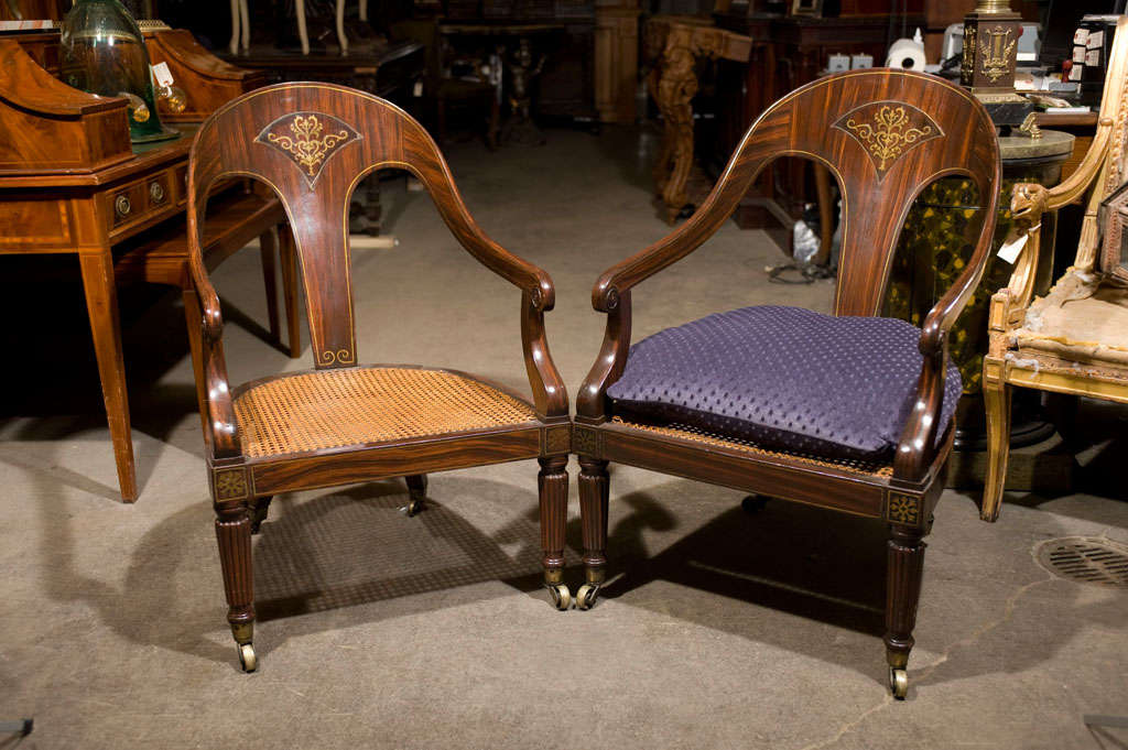 Rare form of period spoon back armchairs with brass inlay detail and caned seats. Original faux rosewood  painted finish with brass castor feet. Large, generous  proportions.