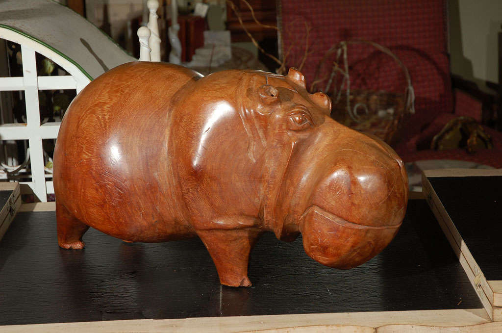 This fat (and heavy--about 50 lbs.) solid wood hippo just makes you smile. It is a hand carved  piece, out of some kind of exotic wood (Mukwa wood) that has a warm caramel colored patina. He is from an estate where the deceased owner had a lot of