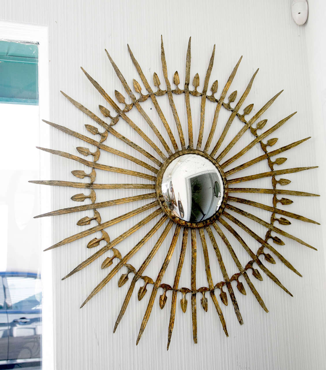 Metal starburst mirror with detailed arms.