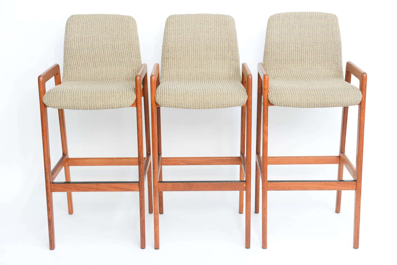 REDUCED FROM $2500 FOR SATURDAY SALE...Wonderfully appointed teak bar stools with curved upholstered bent wood seats.  Quite comfortable design  with arms and foot rest.  Made in Denmark and marked so in the wood underside.  Tarm Stole