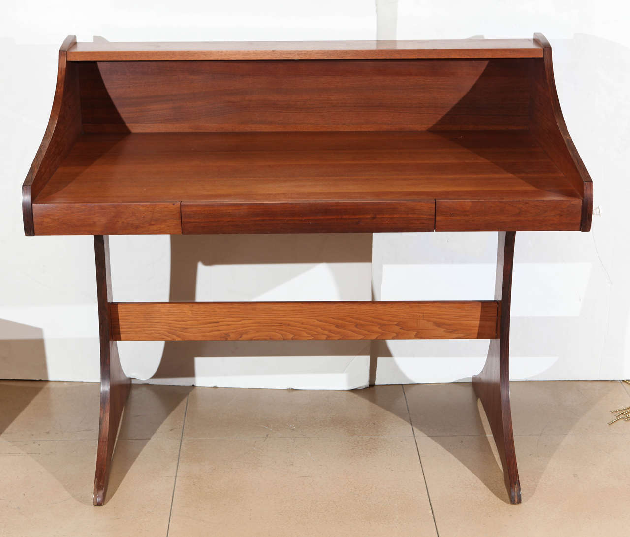A Mid-Century solid walnut desk made by Kroehler from the 1970s with open shelf detail and a single drawer.