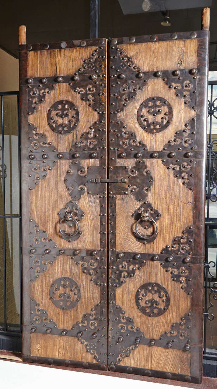 Pair of large Chinese doors with elaborate iron hardware embellishment.