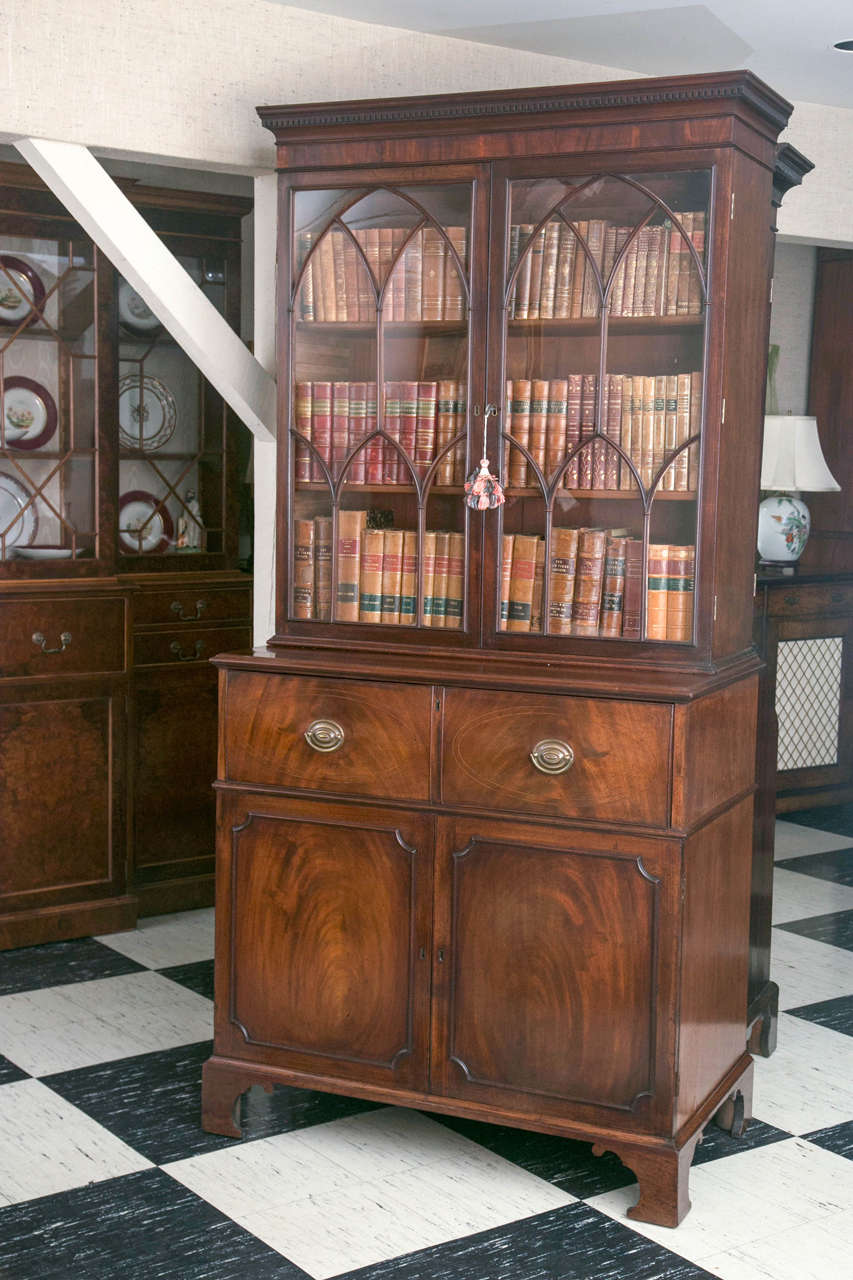 This bookcase with drop front secretary drawer is nicely proportioned and the mahogany has gained a rich patina over the years, but it does not rely on just its looks. The desk is well appointed with regiments of drawers and pigeon holes flanking a