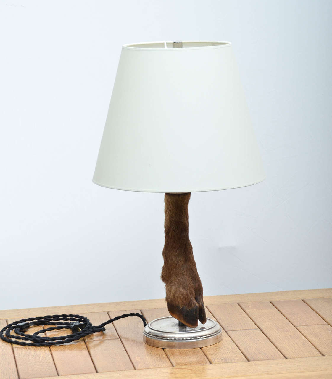 Vintage deer hoof table lamp mounted onto a nickel base. 

This lamp has been newly rewired with polished nickel fittings and a black twisted silk cord. Holds (1) type A bulb. 

Shade not included.