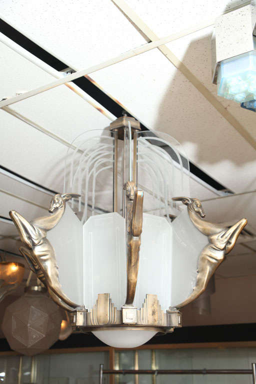 French Art Deco Chandelier by Georges-Marius BORETTI of Lyon, c. 1930<br />
Silvered and patinated bronze decorated with six leaping gazelles and with clear and frosted glass divisions suspended on a bulbous hexagonal column
