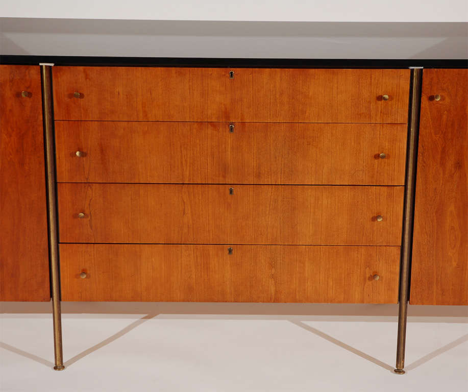 Beautiful large scale Directional Sideboard by Paul McCobb for Calvin Furniture. Rich walnut wood with original finish and heavy black glass top. Four center drawers flanked by segmented doors with two shelves on either side. Rests on eight slender