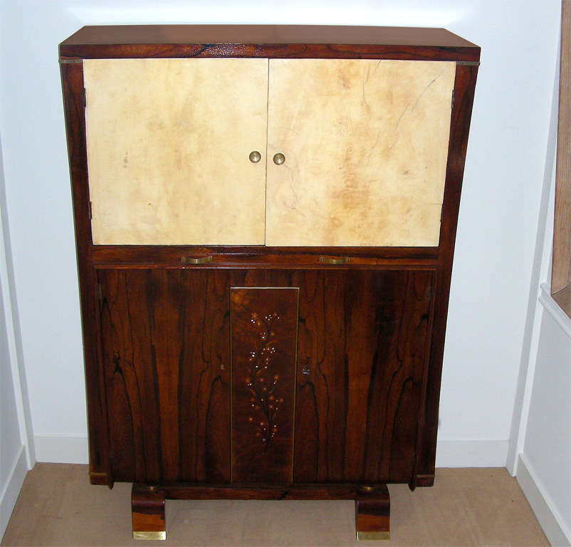 A bar cabinet In the style of jules leleu, made of A magnificent heavy veined jacaranda rosewood  the lower central part of cabinet with inlaid of precious woods and mother of pearl -The sides are curved .in  the middle of the cabinet a sluding