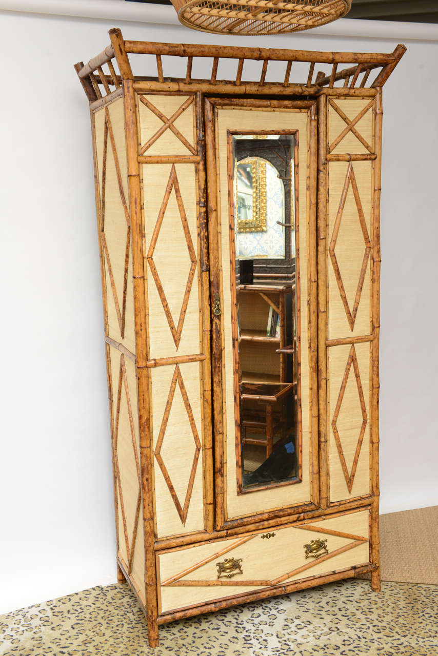 Superb English bamboo wardrobe With Full Length Mirror and Drawer at Bottom. We recover the inside and outside with new grasscloth paper.