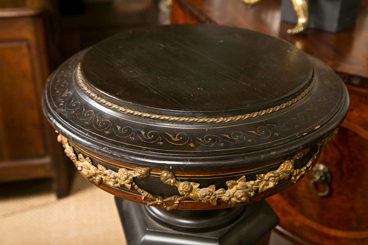 A pair of  ebonized wood pedestals with gilt bronze  mounts, gilt incised decoration and natural wood bandings. The surface area for display are 12 inches in diameter. The center column is six sided.
Please feel free to contact us directly using
