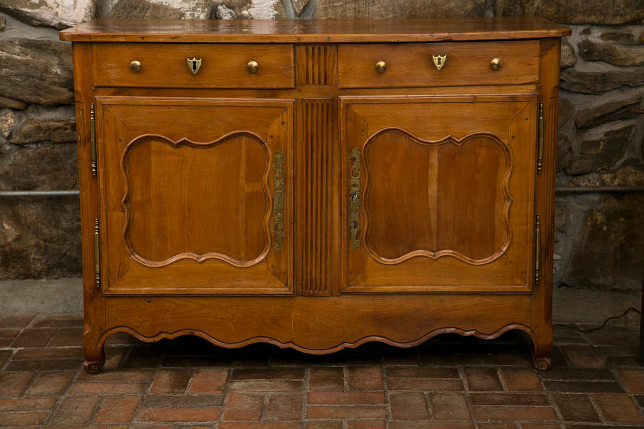 This buffet checked off all the boxes in the buffet catalog when it was created sometime in the 19th century. Classic styling is what it’s all about from the brass knobs and armorial escutcheons to the shaped, recessed panel doors and scalloped