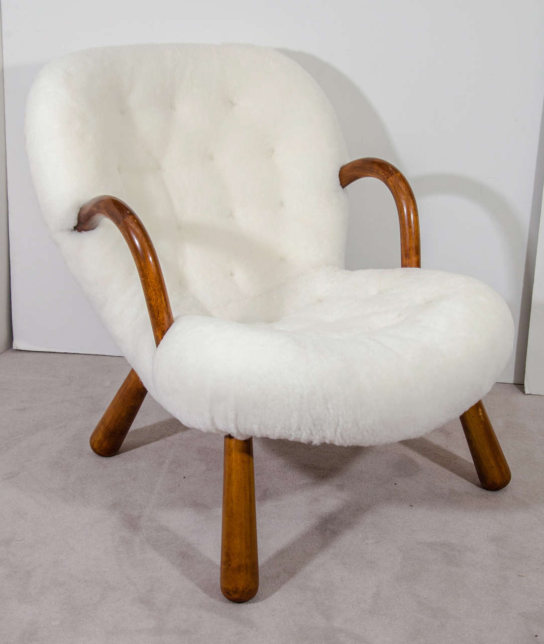 A vintage Danish Modern "Clam" lounge chair by Philip Arctander (the design was until recently widely attributed to Martin Olsen). Originally designed in 1941, the piece has club feet, looped armrests and has been newly reupholstered in