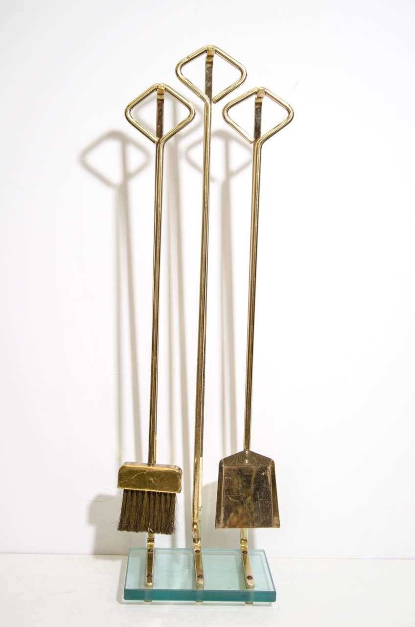 A vintage set of brass fire tools on a brass and glass stand. The piece is attributed to Fontana Arte

There is also a set of andirons available for purchase that compliment this set of fire tools for interested customers.

Reduced from: $4,850