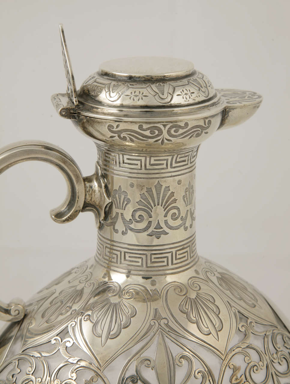 An antique English sterling silver and glass claret jug with star-cut design to glass and typical Victorian engraving on the silver.
It was made by George Fox of London in 1875.
Height is 25.5cms.