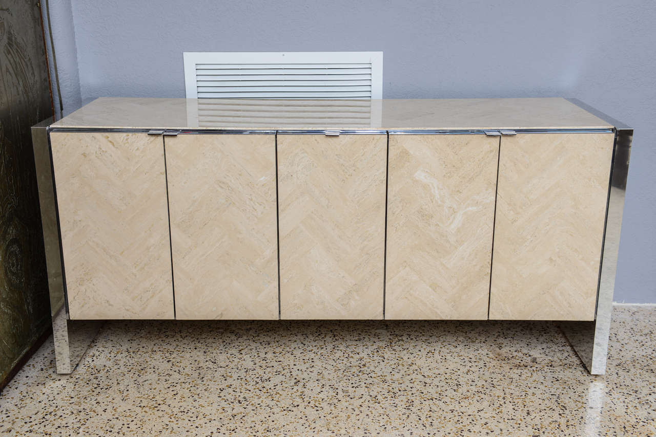 Handsome Ello sideboard has polished steel sides and smart herringbone-patterned travertine top and doors.