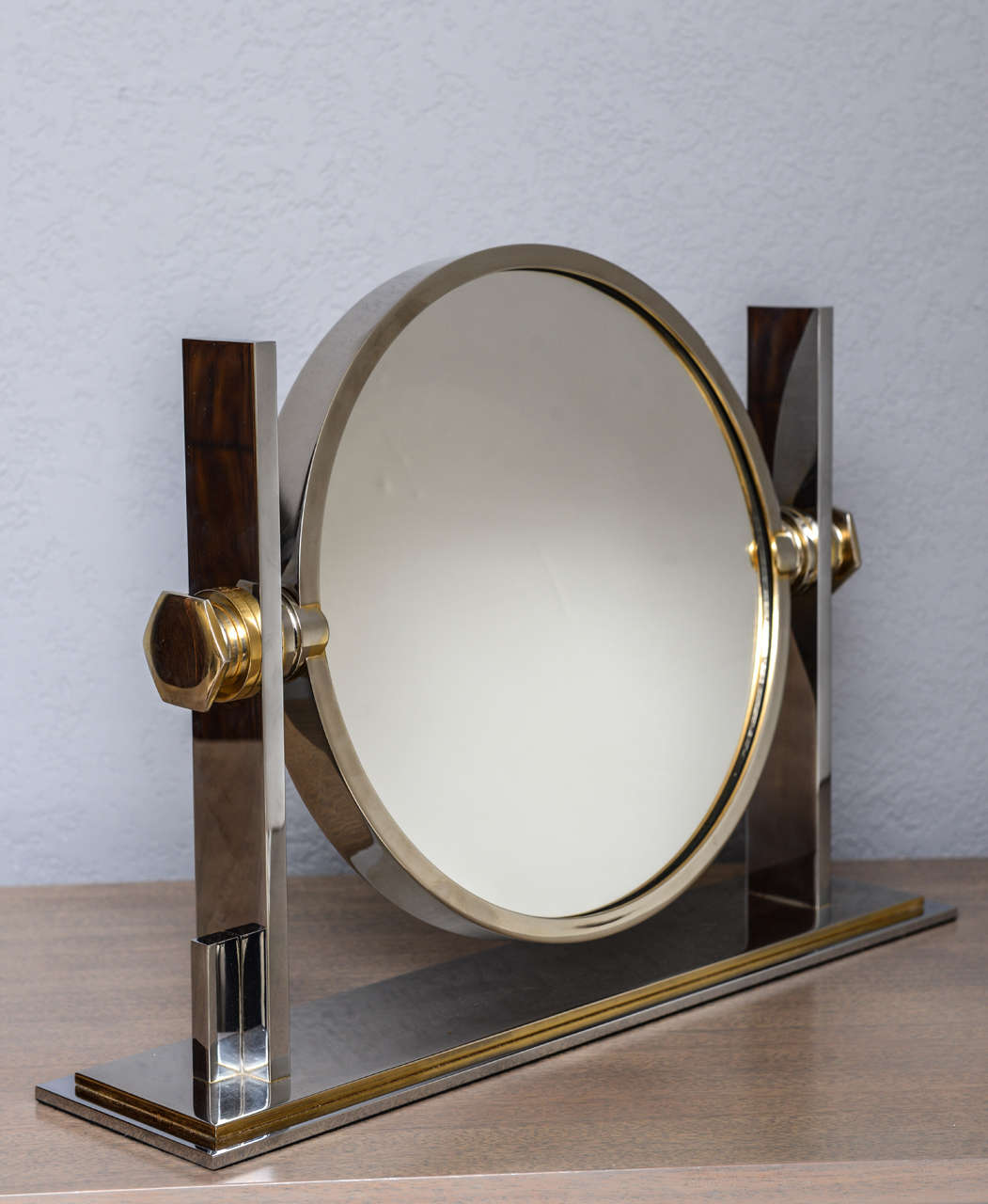 A perennial favorite in the chicest boudoirs... this chrome and brass adjustable vanity mirror by Karl Springer is flat mirror on one side, magnifying on the other.