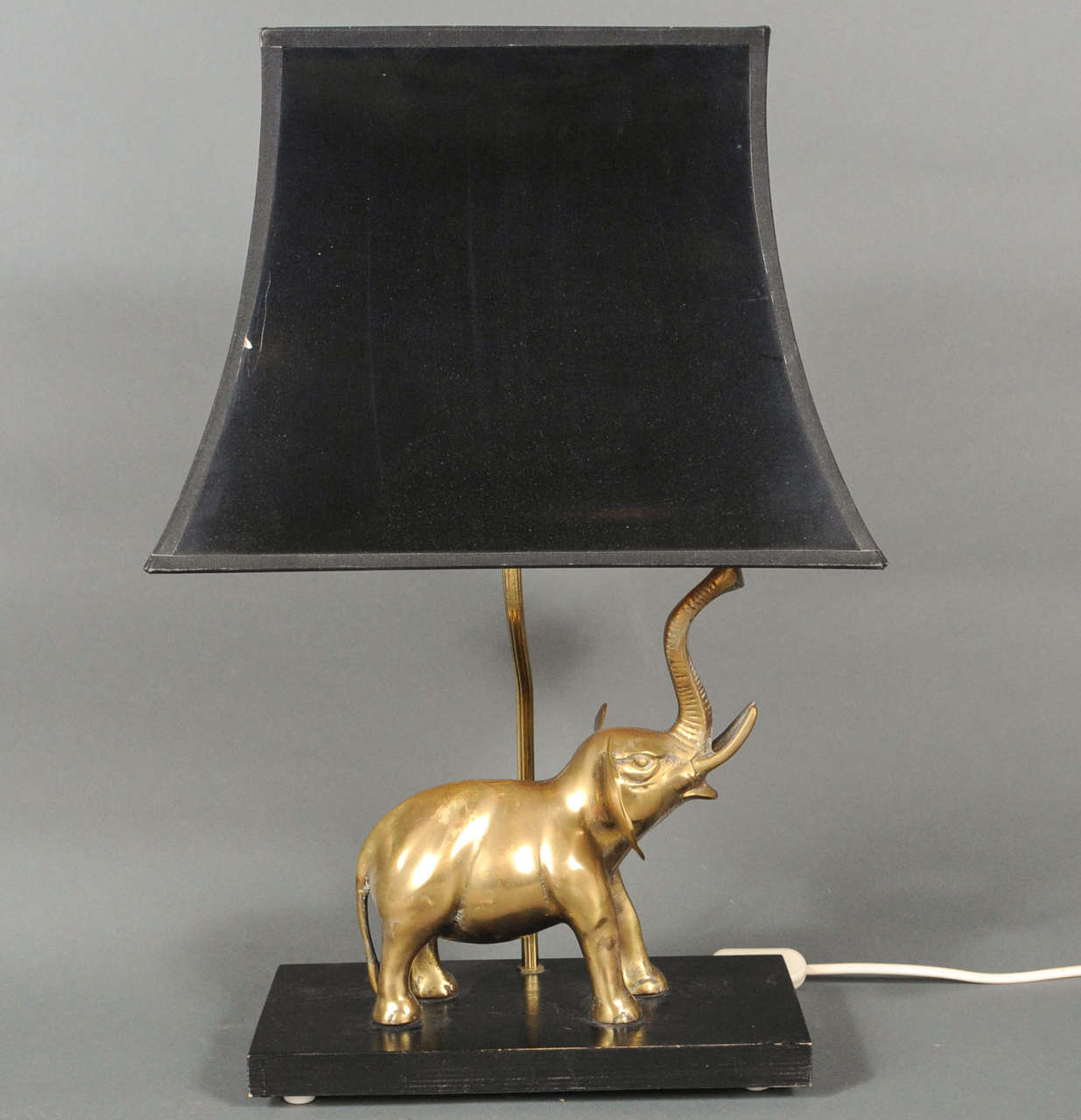 beautiful tablelamp with the original gold/black shade featuring a brass screaming elephant.