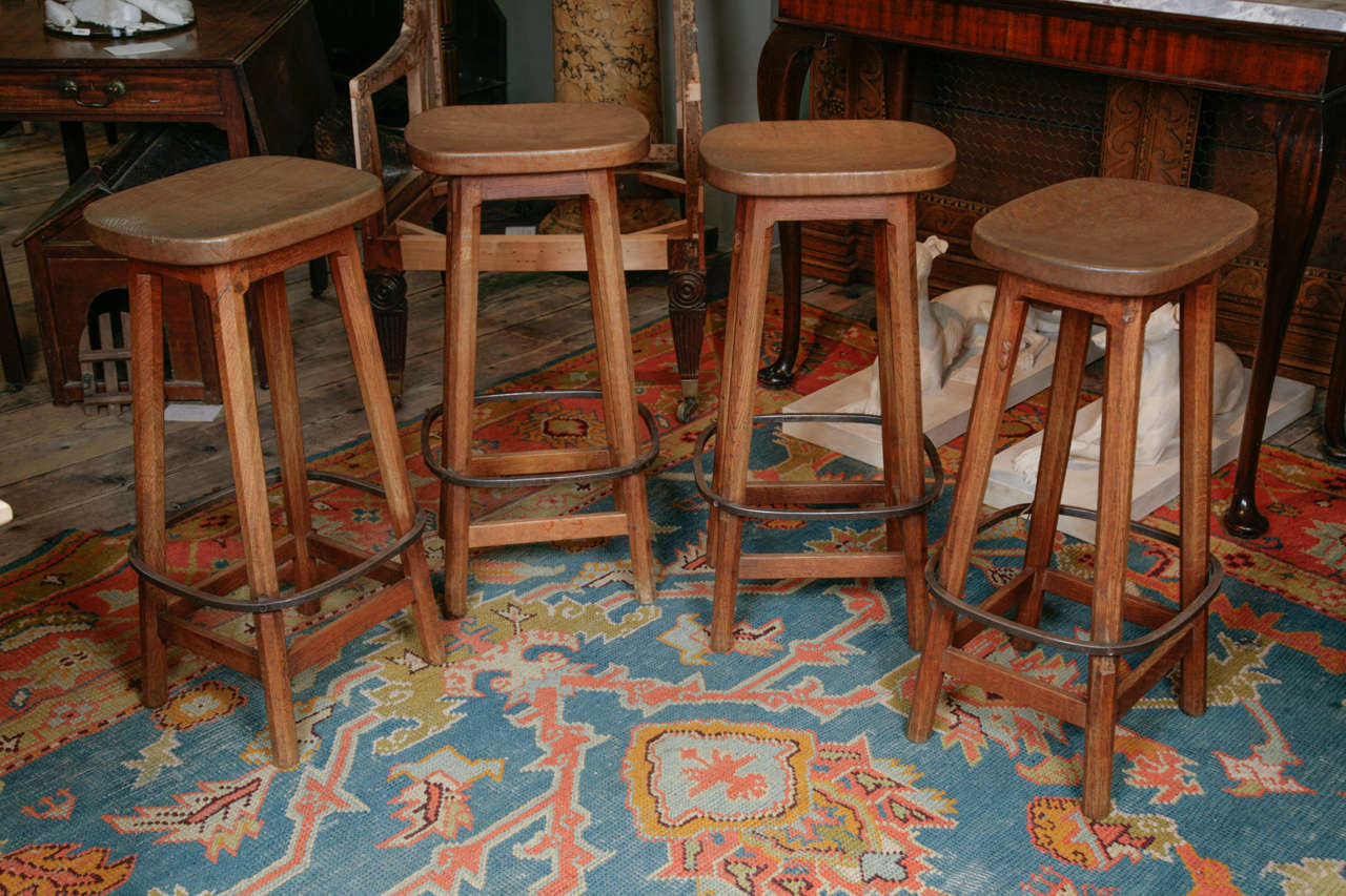 By Robert Thompson of Kilburn, the oval shaped seats on octagonal splayed legs, with metal foot rests and united by plain stretchers, each stool carved with the mouse
