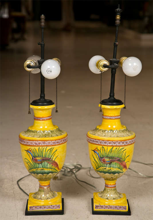 Pair of unusual Italian Faience urn-style lamps. Whimsical bird design on face of each lamp. No shades included.