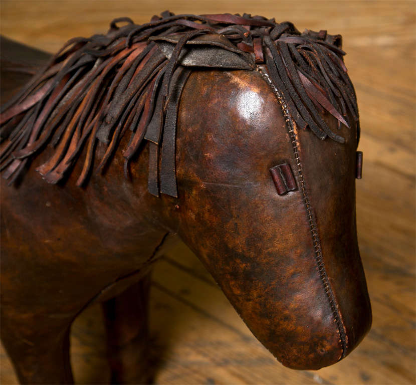 Classic leather pony ottoman by Abercrombie & Fitch. Set tone for mid-century decor, brown leather. Made in England.