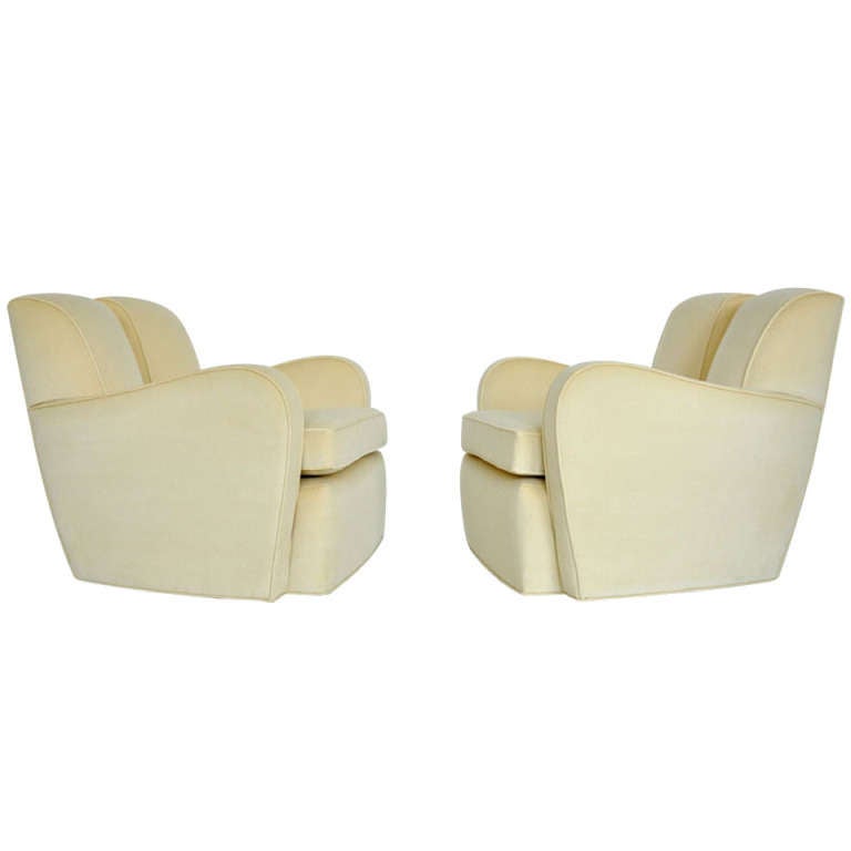 Pair of swivel lounge chairs by Paul Frankl. Beautiful and rare forms newly upholstered in cream velvet.