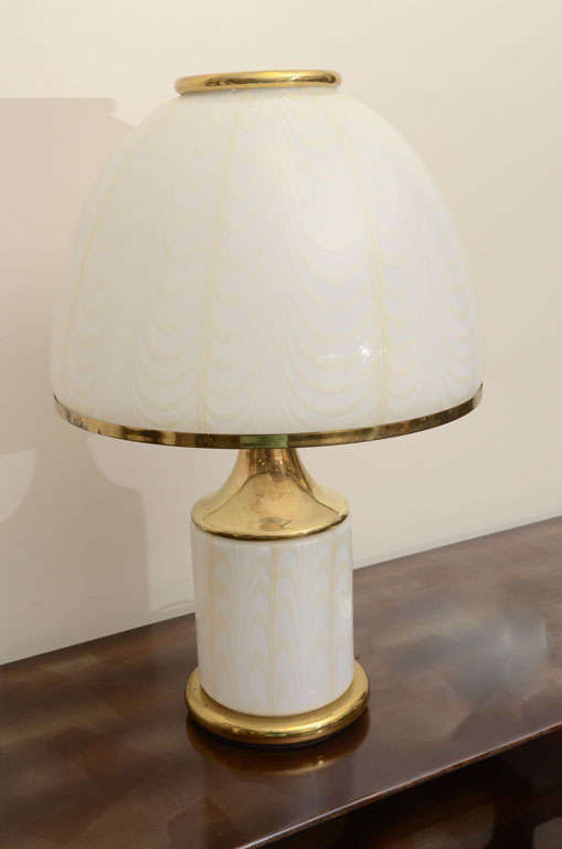 This spectacular single  milk colored murano glass lamp soft amber feather detailingto the shade and lamp body was designed by Italian  F. Fabbian.
The lamp  has been trimmed with polished brass appointments and when illuminated is simply stunning.